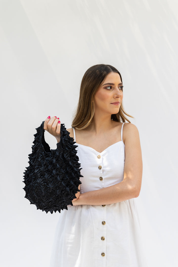 petit bag solid en mano de modelo, color negro