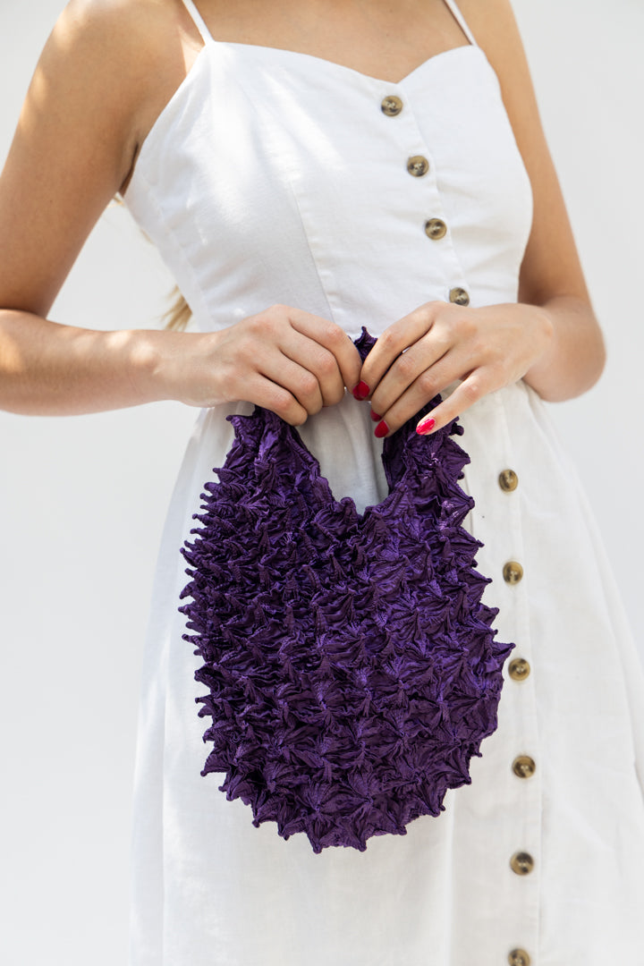 Modelo sosteniendo bolsa petit solid color morado