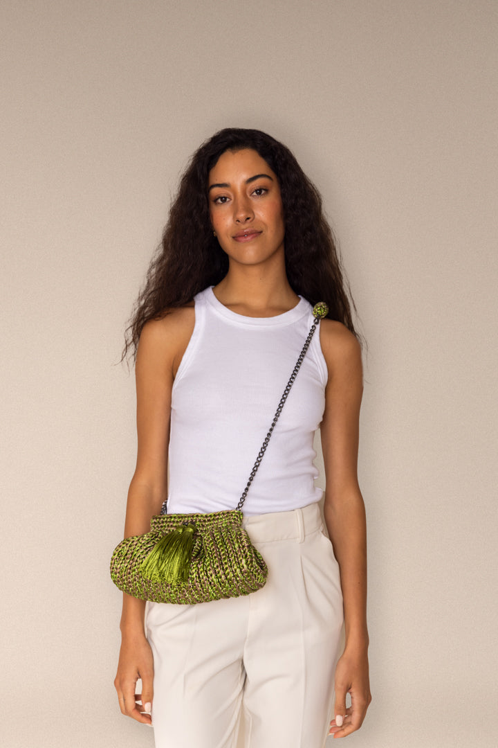 modelo con bolsa cantiga clutch cruzada, color verde